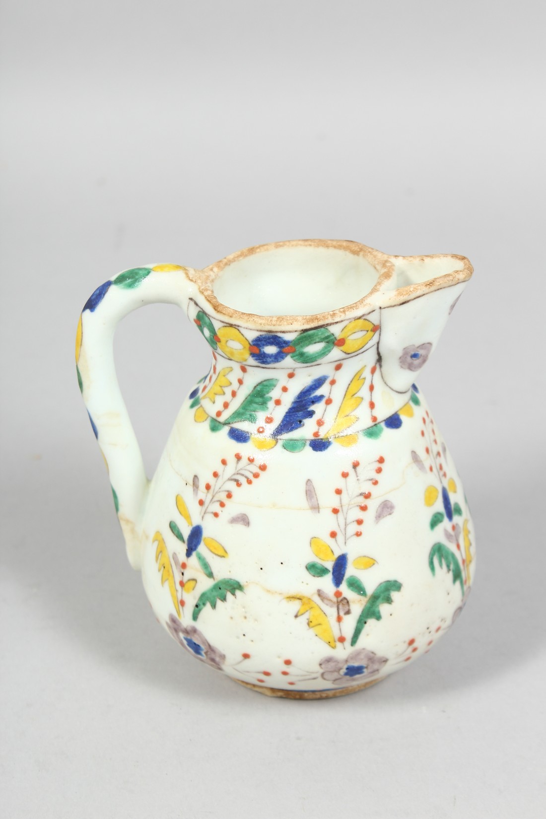 A SMALL TURKISH KUTAYHA POTTERY JUG, decorated with floral motifs, 12cm high. - Image 3 of 6