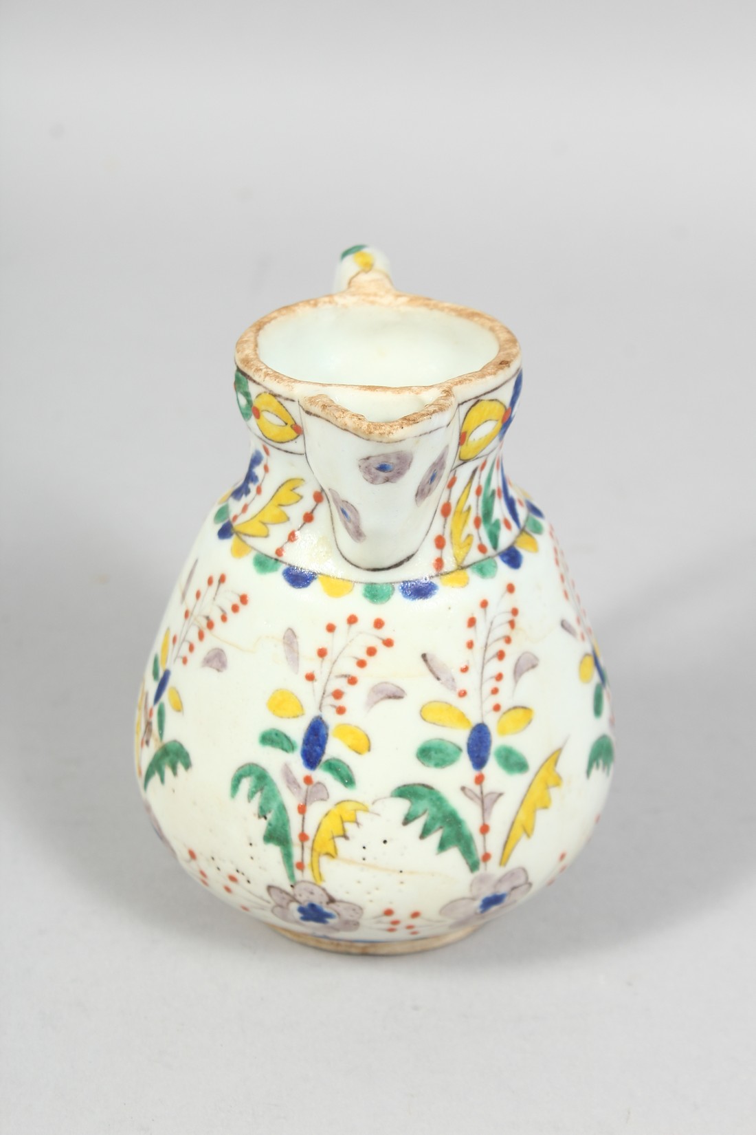 A SMALL TURKISH KUTAYHA POTTERY JUG, decorated with floral motifs, 12cm high. - Image 2 of 6