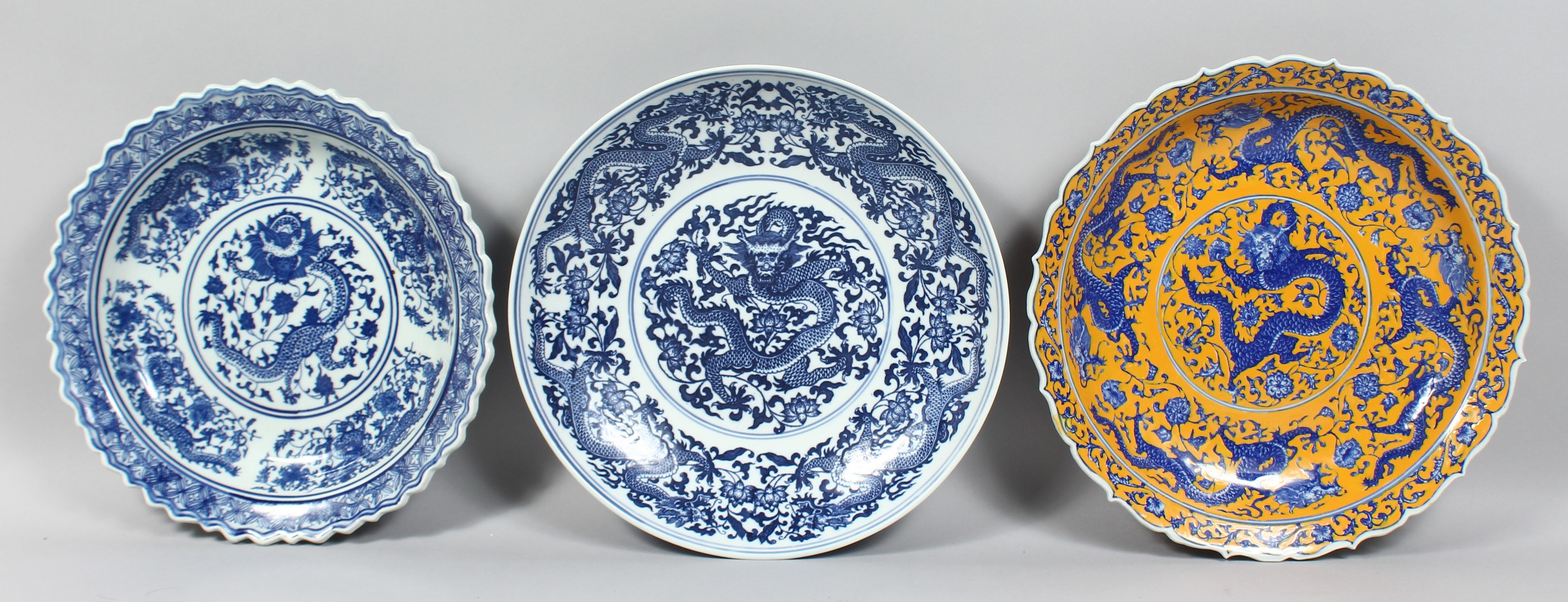 THREE LARGE CHINESE PORCELAIN DISHES, comprising two blue and white and one yellow ground dish; each