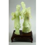 A CHINESE JADE FIGURAL GROUP ON A HARDWOOD STAND, the jade carved as two female figures, mounted