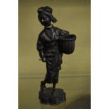 A Japanese cast metal figure of a lady carrying a basket.
