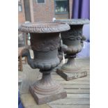 A pair of small cast iron garden urns.