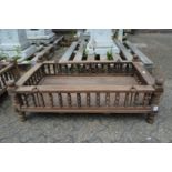 An Indian hardwood rectangular cradle or plant trough with turned spindle supports.