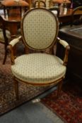 A French carved mahogany and parcel gilded armchair.