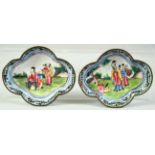 A SMALL PAIR OF CHINESE QUATREFOIL FORM ENAMEL DISHES, painted with figures in a garden, 9cm x 7.