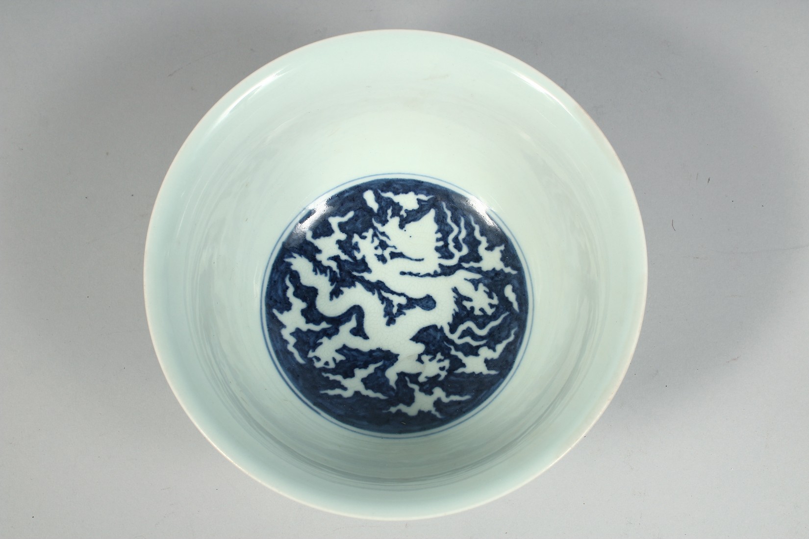 A CHINESE PALE CELADON PORCELAIN BOWL, the exterior with raised decoration depicting dragons and - Image 5 of 7