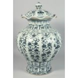 A VERY LARGE CHINESE BLUE AND WHITE PORCELAIN URN AND COVER, painted with various panels of native