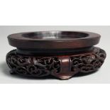 A CHINESE CARVED AND PIERCED OVAL SHAPE HARDWOOD STAND, 15cm wide.