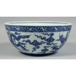 A CHINESE BLUE AND WHITE PORCELAIN BOWL, the exterior decorated with dragons and stylised clouds,