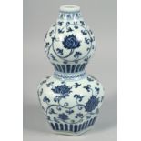 A CHINESE BLUE AND WHITE PORCELAIN DOUBLE GOURD VASE decorated with lotus and scrolling vine,