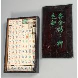 A CHINESE BOXED MAH JONG SET with bone and wood counters, box 26.5cm x 16cm.