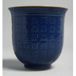 A CHINESE BLUE GLAZE PORCELAIN CUP, the exterior with calligraphy, base with six-character mark, 9cm