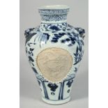 A CHINESE BLUE AND WHITE TWIN HANDLE PORCELAIN VASE, the body with two unglazed panels of a carved