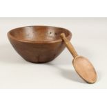 A TREEN CIRCULAR BUTTER BOWL AND SPOON. 10.5ins diameter.