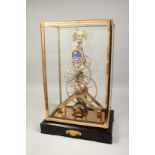 A GOOD BRASS AND ENAMEL MOON FACE SKELETON CLOCK surrounded by an eagle. 17ins high in a glass