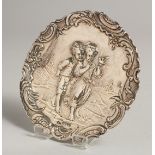 A CONTINENTAL SILVER DISH repousse with children. 4ins diameter. London imported mark, 1910.