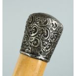 A VICTORIAN CANE with silver handle, repousse scroll decoration by W. Cornyns. 35ins.