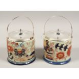 A PAIR OF PORCELAIN BISCUIT BARRELS with plated top and handle.