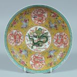 A CHINESE FAMILLE JAUNE CIRCULAR DISH decorated with dragons. 8ins diameter.