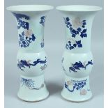 A PAIR OF CHINESE BLUE AND WHITE YEN-YEN VASES decorated with flowers and leaves. 10.5ins high.