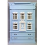 A CHILD'S BLUE HOUSE WARDROBE OF GEORGIAN DESIGN with two doors with shelves, two long drawers to