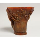 A GOOD CHINESE CARVED HORN LIBATION CUP carved with birds and lotus 5.5ins high.