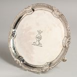 A GEORGE III SILVER WAITER, 6.5ins diameter with a gadrooned and shell border or three pad feet.