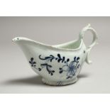 A JAMES PENNINGTON SAUCE BOAT with moulded borders painted in blue under glaze with flowers,