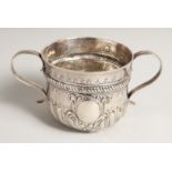 A GEORGE I SILVER TWO HANDLED PORRINGER with repousse decoration, fluted body. 3ins diameter, 2.5ins