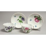 TWO MEISSEN CUPS AND SAUCERS painted with flowers. Mark in blue.