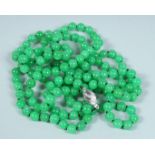 A STRING OF JADE BEADS, long row with white gold clasp.
