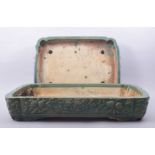 TWO LARGE CHINESE GREEN GLAZED RECTANGULAR PLANTERS, with raised floral decoration. 51cm x 38cm