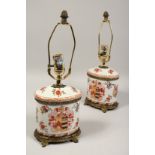 A PAIR OF ARMORIAL PORCELAIN OVAL LAMPS. 16ins high.