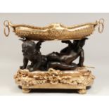 A SUPERB BRONZE AND GILT BRONZE OVAL TWO HANDLED CHERUB BOWL held by two cupids. 15ins high, 21ins
