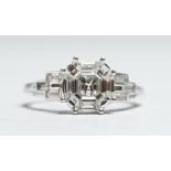 AN 18CT WHITE GOLD DIAMOND SET RING. The central diamond cluster of 1.17cts, the baguette diamonds