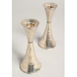 A PAIR OF.800 SILVER HAMMERED CANDLESTICKS. 6ins high.