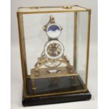 A GOOD BRASS AND ENAMEL MOON FACE SKELETON CLOCK in a glass case.