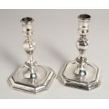 A MATCHED PAIR OF GEORGE I SILVER AND GEORGE II SILVER CAST CANDLESTICKS. London 1725 & 1735.