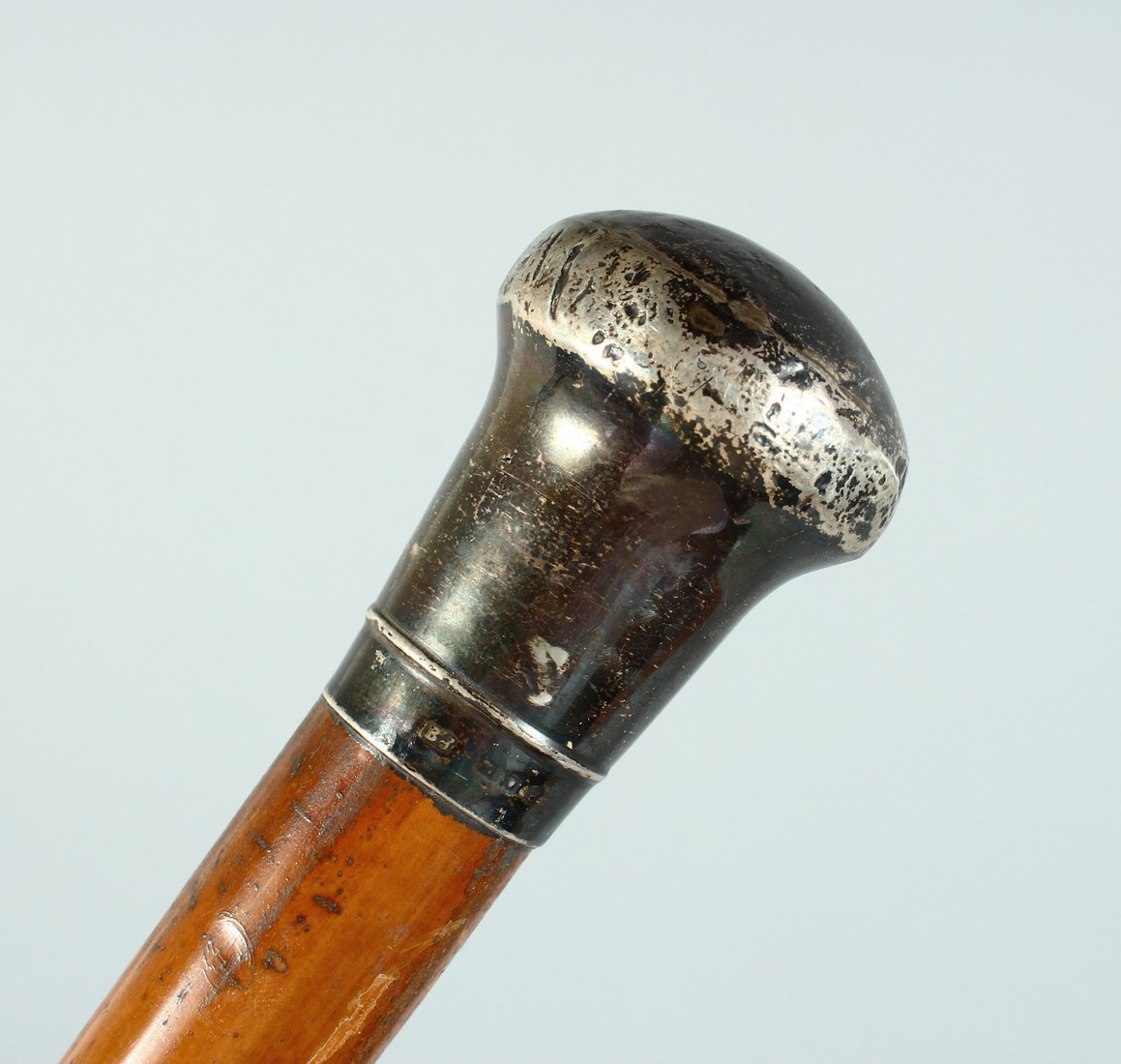 AN EDWARD VII CANE with plain silver handle. London 1901, 35ins long.