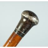 AN EDWARD VII CANE with plain silver handle. London 1901, 35ins long.