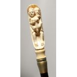 A BONE HANDLED WALKING STICK CARVE AS AN EROTIC SCENE. 35ins long