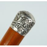 A VICTORIAN CANE with silver handle, repousse scroll decoration Birmingham, 1890, maker W & L. 36ins