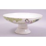 A CHINESE PORCELAIN PEDESTAL DISH / FRUIT BOWL, painted with two seated figures next to a tree. 23cm