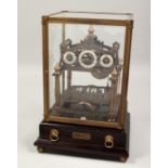 A CONGREAVE BRASS ROLLING BALL CLOCK in a glass case. 11ins high.