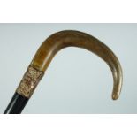 A VICTORIAN WALKING STICK with Rhino handle and gilt band., 35ins long.