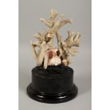 A LARGE CORAL SPECIMEN on a wooden stand. 9ins long.