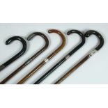 FIVE VICTORIAN WALKING STICKS with silver bands.