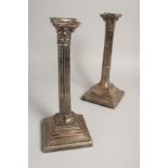 A PAIR OF CORINTHIAN COLUMN CANDLESTICKS on loaded square bases. 12ins high Sheffield 1919. Maker W.