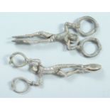 A PAIR OF VICTORIAN CAST SILVER HARLEQUIN SUGAR TONGS. London, 1858, maker, W M. and a plated