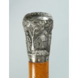 AN INDIAN CANE with silver handle decorated with figures, trees and buildings. 35ins long.